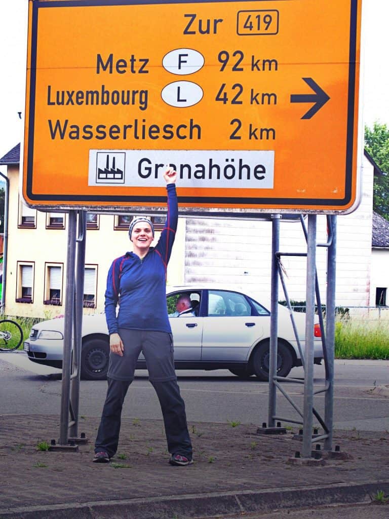 Carola with road sign to Luxembourg and France, Germany (2014-06)