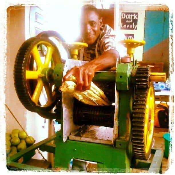 Man making sugar cane juice with a big machine, Mombasa, Kenya (2012-05)