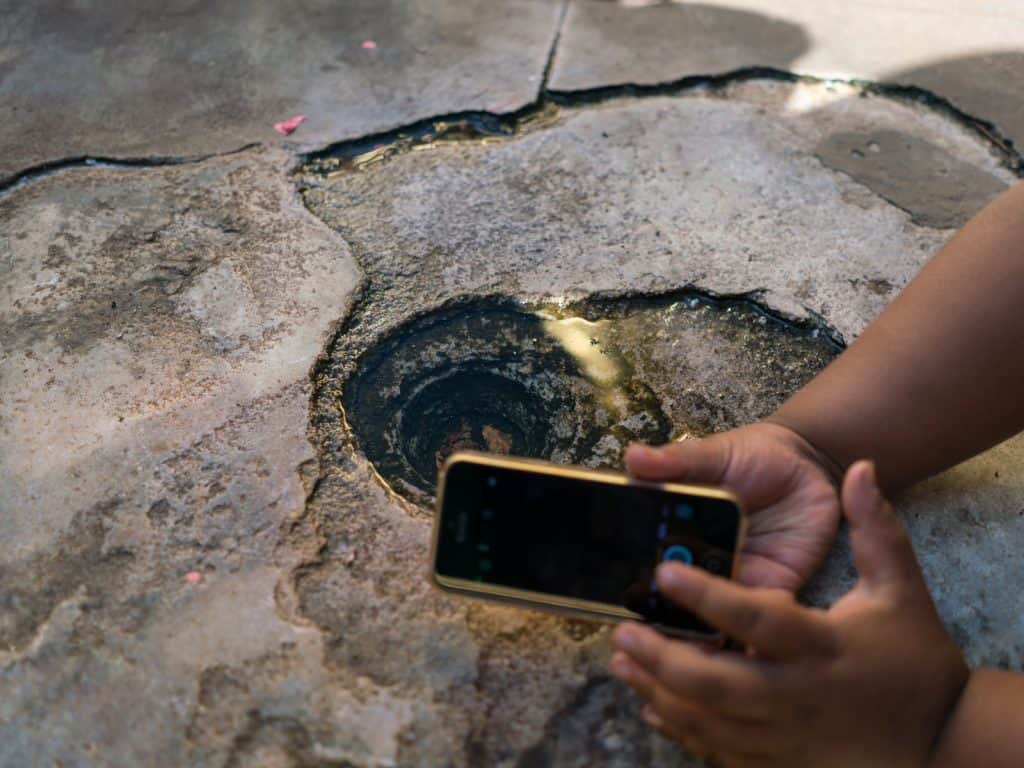 Boy taking photos at tiny reflection pool at Shwezigon Pagoda, Bagan, Myanmar (2017-09)