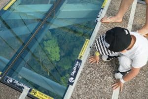 Boy looking through glass floor at SkyBridge, Langkawi, Malaysia