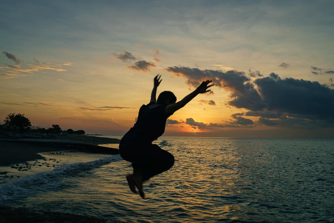 Carola jumping at sunset in Pante Macassar, Oecusse, East Timor